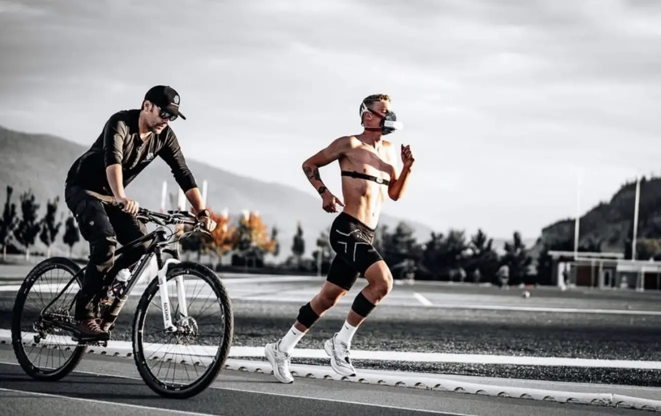 Coach Luke Way riding alongside Brock Hoel during respiratory field testing